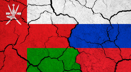 Flags of Oman and Russia on cracked surface - politics, relationship concept