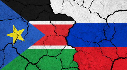 Flags of South Sudan and Russia on cracked surface - politics, relationship concept