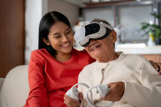 Senior woman enjoying in Metaverse world with young woman at home. Innovation, Metaverse, VR, technology concept. - Powered by Adobe