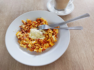 Healthy breakfast with scrambled eggs, meat and cheese as ingredients