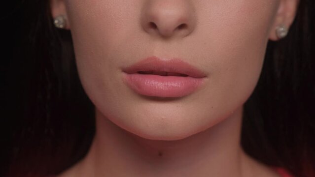 Beautiful lips Close-up. Makeup. Lip matte lipstick. The girl bites her lips.