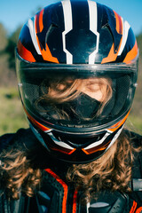 Portrait of fashion young man wearing long hair and  motorcycle helmet outdoor