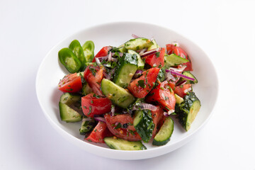 Salad of fresh cucumbers and tomatoes in a plate. selective focus.