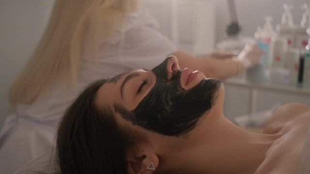 Carbon peeling of the face of a young beautiful girl. Skin care cosmetology. Laser therapy and skin treatment.