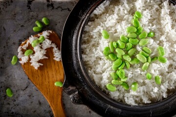 Wholesome Fusion: Top Close-Up of Edamame Served on Steamed White Rice in a Cast Iron Pot, Captured in 4K Resolution