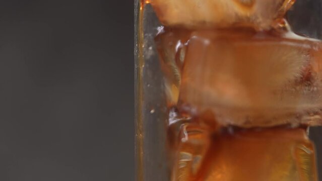 Slow motion pour cold brew coffee over ice 