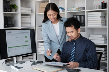 Young professional business team working and analyzing the project together, using desktop monitor in the office room.