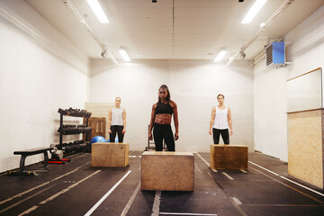 Diverse women ready for box jump workout in a gym