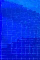 Blue tiles of a swimming pool under the water