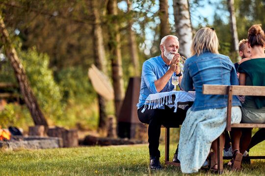 Man talking with family outside at a table