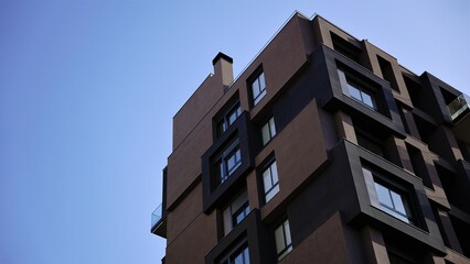 low angle corner of dark facade of modern residential building against sky