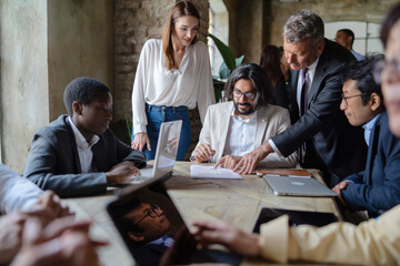 Multicultural Business Team Signing Agreement During Strategic Meeting