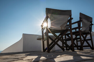Santorin Stühle auf Terrasse mit Sonne im Gegenlicht - 627801972