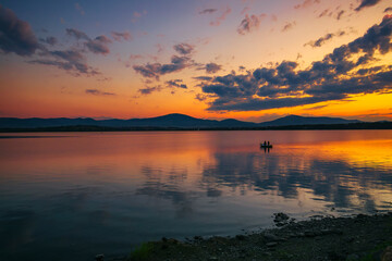 Widok na letni zachód słońca, jezioro z żaglówkami
