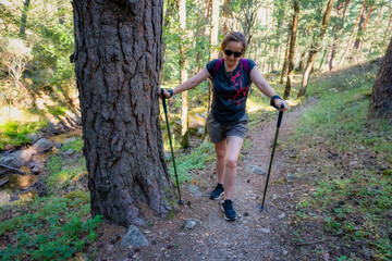 Senior woman hiking along a steep path in a forest in Guadarrama, Madrid.