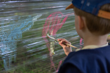 boy paints on stretch film in the woods, perfect time to play
