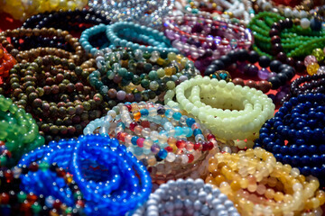Women's Jewelry, small business. Handmade bracelets made of multi-colored beads on the counter of a street market, full frame. Close-up. Selective focus.