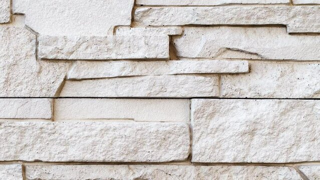 Wall, masonry of flat stones beige uneven, moving sideways, close-up macro, top view
