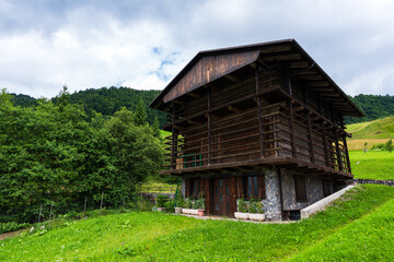 Obraz premium pretty little wooden house, in the middle of green hills