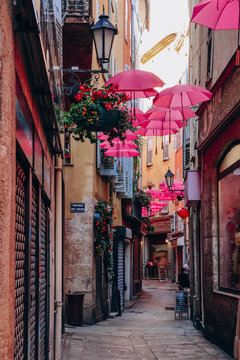 Fototapeta Grasse, France - July 23, 2023: Famous pink umbrellas decorating the central streets of Grasse