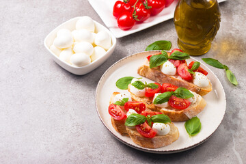Tomato, basil and mozzarella cheese fresh made caprese bruschetta. Italian tapas, antipasti with vegetables, herbs and oil on grilled ciabatta and baguette bread. Open sandwich.