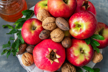 Pomegranate, apple , nuts  and honey, traditional food of jewish New Year celebration, Rosh Hashana. Selective focus.