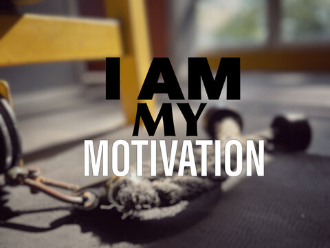Motivational and inspirational wording. Health and fitness concept. I Am My Motivation written on blurred background of gym equipment.