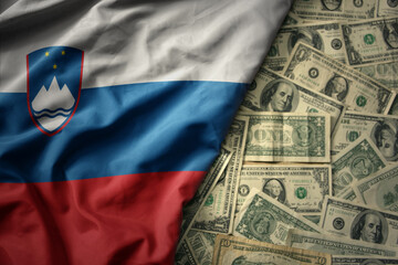 colorful waving national flag of slovenia on a american dollar money background. finance concept