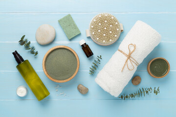 Composition with cosmetic clay and spa products on wooden background, top view