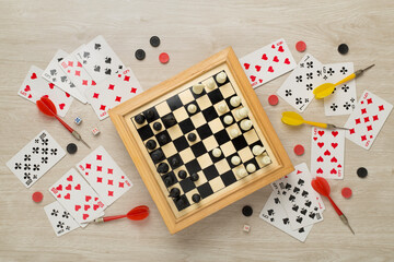 Different board games on wooden background, top view
