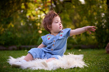 Adorable girl on the grass in the garden. Close up portrait. Happy little girl in summer scenery....