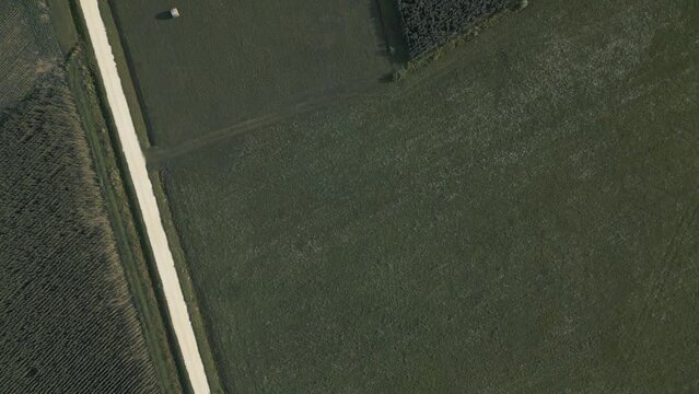 Aerial shot after the storm of a prairie with hay bales and deserted fields. Clouds without rain, sun and greenery.