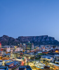 Fototapeta na wymiar Vertical long exposure shot of Cape Town city and the table mountain in the background with blue sky, Cape Town, South Africa