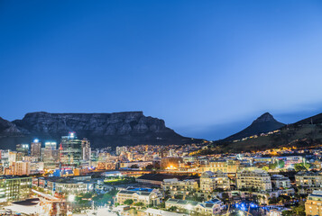 Panorama shot of Cape Town city illuminated buildings with the table mountain and Lion's Head in...