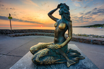 Mermaid statue by the Baltic Sea in Ustka at sunrise. Poland
