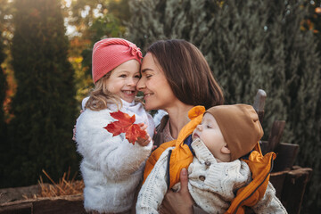 Obraz premium Cheerful family on the farm. Parenting and childhood. Motherhood. Autumn Thanksgiving Day. Outdoor games. Harvesting at farm. Vacation home. Yard decor