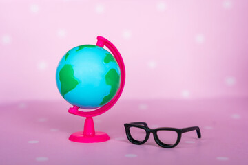 Toy black glasses and globe close-up. Back to school concept