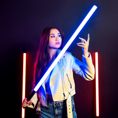 Led light stick in female hands. Beautiful Asian woman holding handheld led lighting wand.