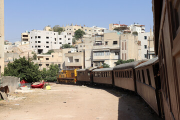 Obraz premium Amman, Jordan (a train among houses) An old Turkish Ottoman steam train in Jordan - Hedjaz Jordan Railway