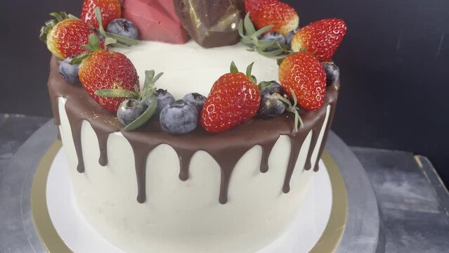 Close up cake with chocolate drips, strawberry and blueberry. Cake with hearts. 4k. Wedding cake.