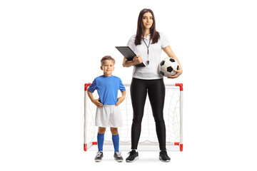 Fototapeta premium Boy and a female football coach posing in front of a mini goal