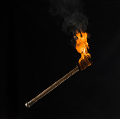 burning wooden torch isolated on black background - 627856139