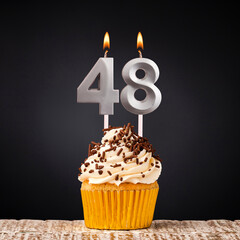 Birthday candle number 48 - Anniversary cupcake on black background