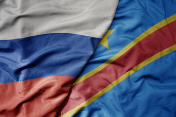 big waving realistic national colorful flag of russia and national flag of democratic republic of the congo .