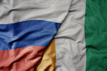 big waving realistic national colorful flag of russia and national flag of cote divoire .