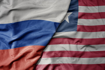Obraz premium big waving realistic national colorful flag of russia and national flag of liberia .
