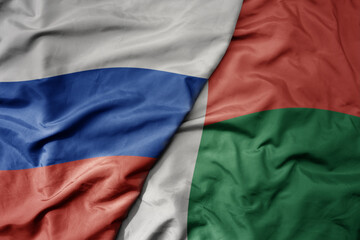 big waving realistic national colorful flag of russia and national flag of madagascar .