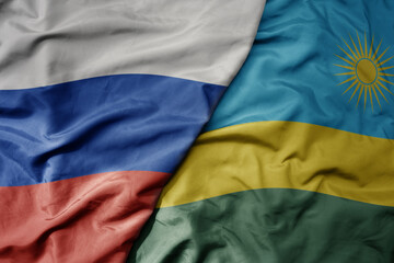 big waving realistic national colorful flag of russia and national flag of rwanda .