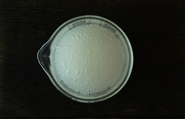 Guar gum liquid in measuring cup, top view. Food additive E412.