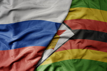 big waving realistic national colorful flag of russia and national flag of zimbabwe .